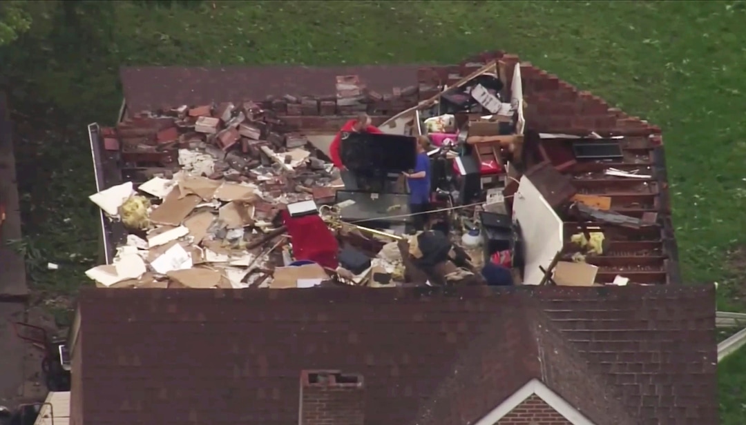 (KMOV-TV via AP) This still image provided by KMOV-TV shows people going through their belongings after a tornado destroyed the roof of their home on Thursday, May 23, 2019 in Jefferson City, Mo.  The National Weather Service confirmed that the large and destructive twister moved over Jefferson City shortly before midnight Wednesday.