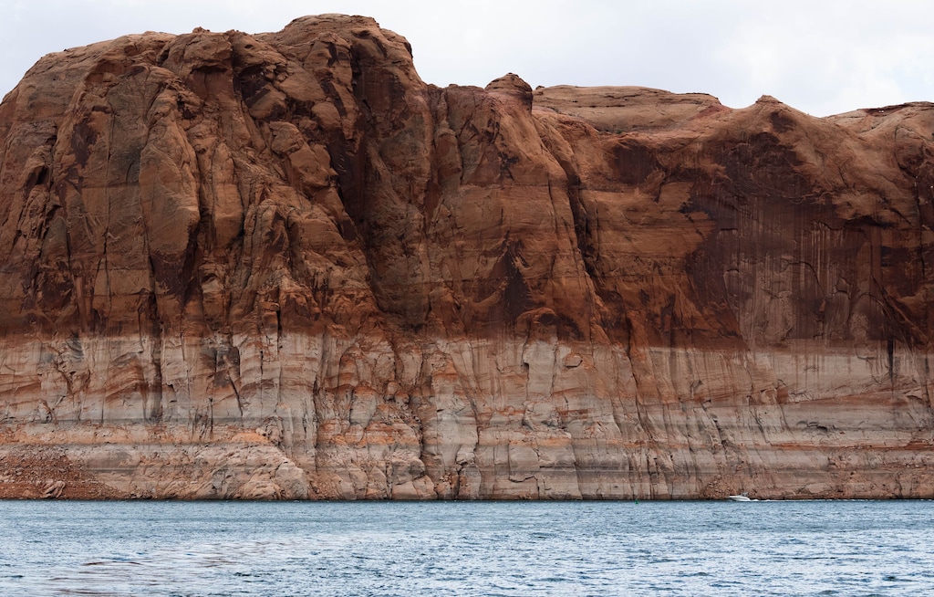 (Francisco Kjolseth | The Salt Lake Tribune) A motor boat navigates the main channel of Lake Powell on Sunday, April 26, 2026, as bathtub rings are indicative of how far the waters levels have fallen since being at full capacity in the early 1980s. 