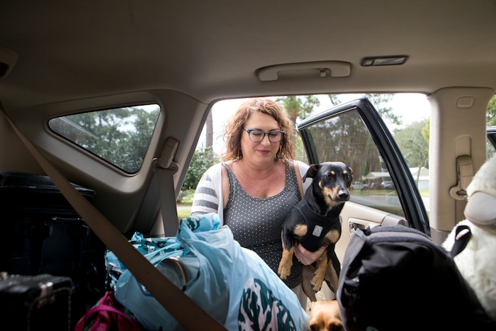 (Joshua Boucher | News Herald | The Associated Press) Julie Logsdon loads her dogs Tobias and Luna into her car in Panama City, Fla., as Hurricane Michael approaches on Tuesday, Oct. 9, 2018. She is evacuating with her husband, four pets and belongings that could get damaged if the house leaks.