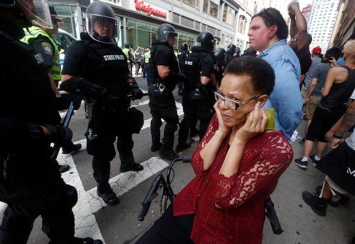 A woman covers her ears as police officers line the street near a "Free Speech" rally staged by conservative activists on Boston Common, Saturday, Aug. 19, 2017, in Boston. Counterprotesters marched through the city to historic Boston Common, where many gathered near a bandstand abandoned early by conservatives who had planned to deliver a series of speeches. Police vans later escorted the conservatives out of the area, and angry counterprotesters scuffled with armed officers trying to maintain order.
(AP Photo/Michael Dwyer)