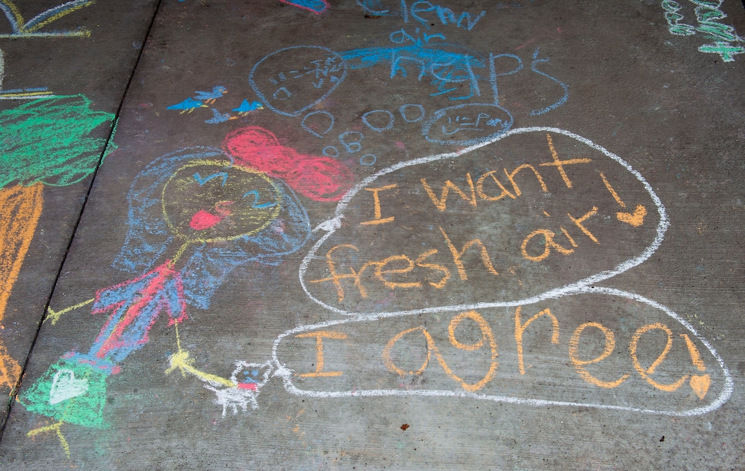 (Rick Egan  |  The Salt Lake Tribune)   Carolyn Hoffert and Angie Parkin and their kids draw chalk art on the sidewalk at Lehi City Hall to protest the expansion of Geneva Rock's mining activities near their neighborhood, Tuesday, April 2, 2019.
