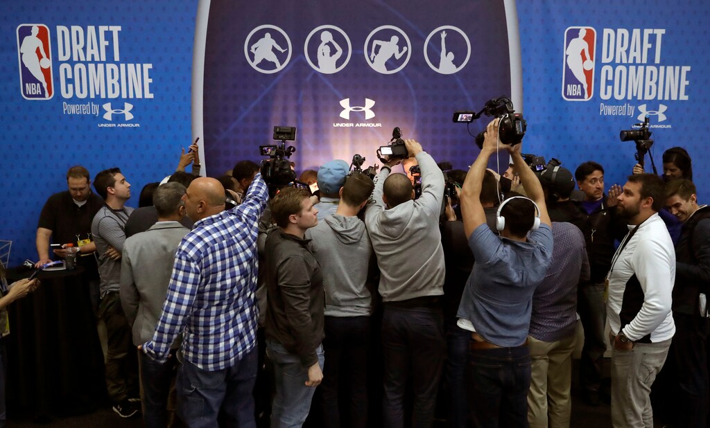 (AP Photo/Charles Rex Arbogast, File) | This scene — the media scrum — has been a tradition, along with player workouts and 5-on-5 scrimmages at past NBA Draft combines. But that has all changed in 2020 with most of the team-player interactions happening virutally, or on tape, because of Covid-19.