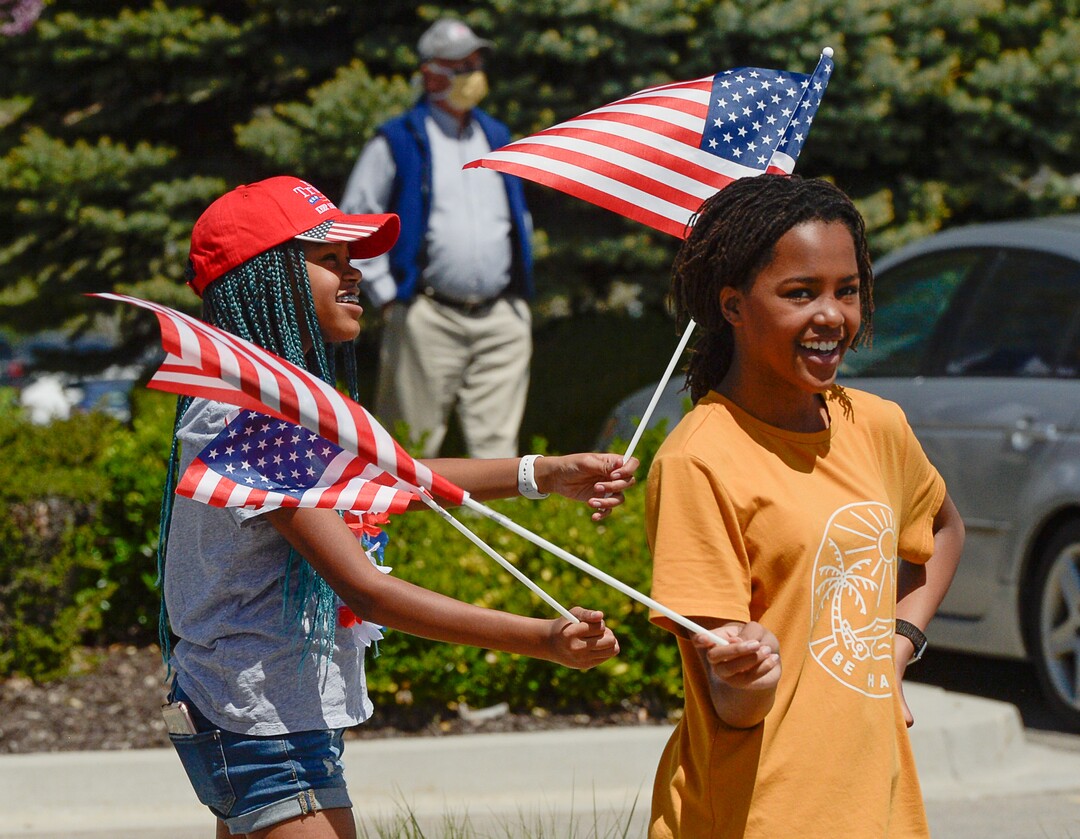 (Francisco Kjolseth  |  The Salt Lake Tribune) Twin sisters Brikelle and Margie Nielsen, 14, from left, dance around with flags as the Air Force F-35A Lightning II Demonstration and 388th Fighter Wing, based at Hill Air Force Base, performs a formation flyover near Intermountain Health Center in Murray on Thursday, April 30, 2020. The demonstration over Utah was a "salute to everyone on the front lines in the fight against COVID-19, as well as those staying at home to flatten the curve of the virus," according to a news release.