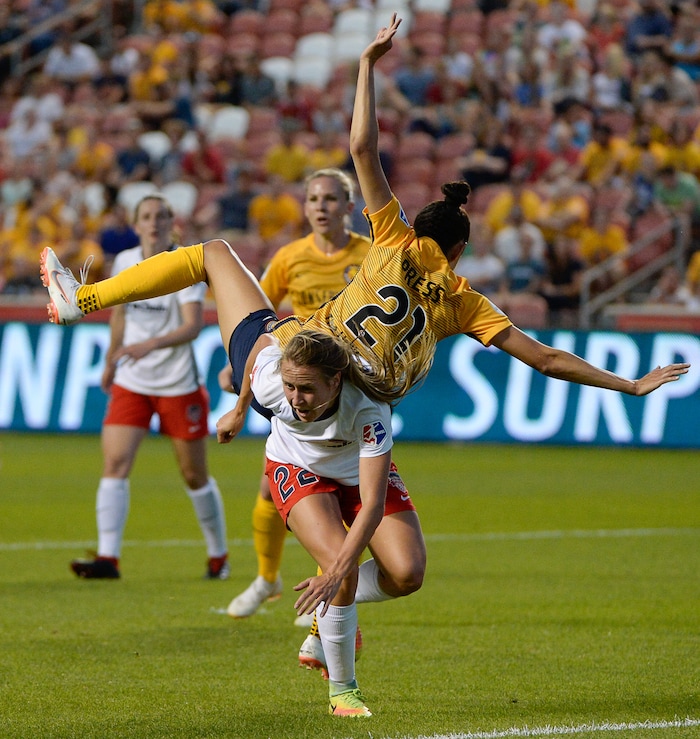 (Francisco Kjolseth  |  The Salt Lake Tribune)  Utah Royals FC hosts Washington Spirit, NWSL soccer at Rio Tinto Stadium in Sandy, Wed. Aug. 8, 2018. Utah Royals FC forward Christen Press (21) ends up in a precarious place over Washington Spirit forward Mallory Eubanks (22) following a header in the first half of the game. 