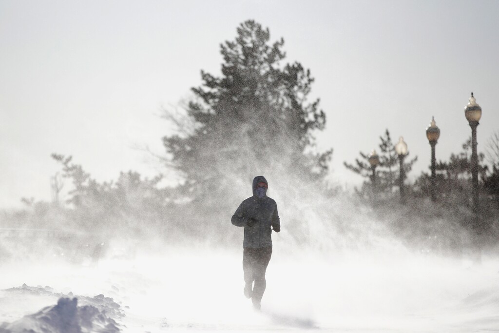 Gusty wind picks up snow accumulated on the ground as Jesse Sherwood, of Jersey City, N.J., jogs at Liberty State Park, Saturday, Jan. 6, 2018, in Jersey City. About 100 million people faced a new challenge after the whopping East Coast snowstorm: a gusty deep freeze, topped Saturday by a wind chill close to minus 100 on New Hampshire's Mount Washington that vied for world's coldest place. (AP Photo/Julio Cortez)