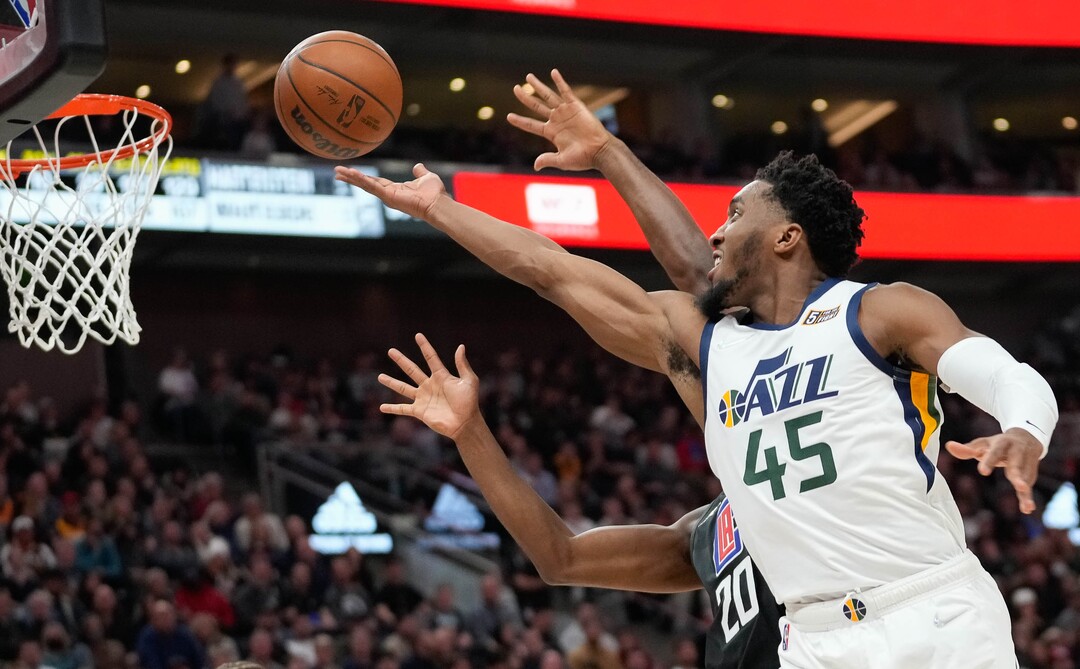 (Francisco Kjolseth | The Salt Lake Tribune) Utah Jazz guard Donovan Mitchell (45) drops one in past LA Clippers forward Justise Winslow (20) in NBA action between the Utah Jazz and the LA Clippers at Vivint Smart Home Arena in Salt Lake City, Wednesday, Dec. 15, 2021.