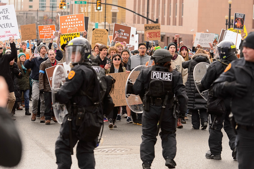 (Trent Nelson | The Salt Lake Tribune)  Police back up as protesters approach downtown after a rally against a visit by President Donald Trump, Monday December 4, 2017.