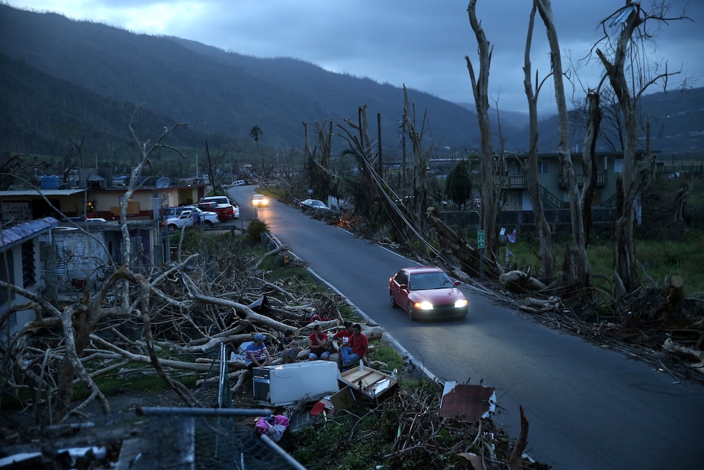 (Gerald Herbert | The Associated Press) In this Sept. 26, 2017, file photo, neighbors sit on a couch outside their destroyed homes as sun sets in the aftermath of Hurricane Maria, in Yabucoa, Puerto Rico. U.S. government forecasters are expecting an active Atlantic hurricane season. The National Oceanic and Atmospheric Administration forecast released Thursday, May 24, 2018, calls for about 10 to 16 named storms, with about five to nine hurricanes.