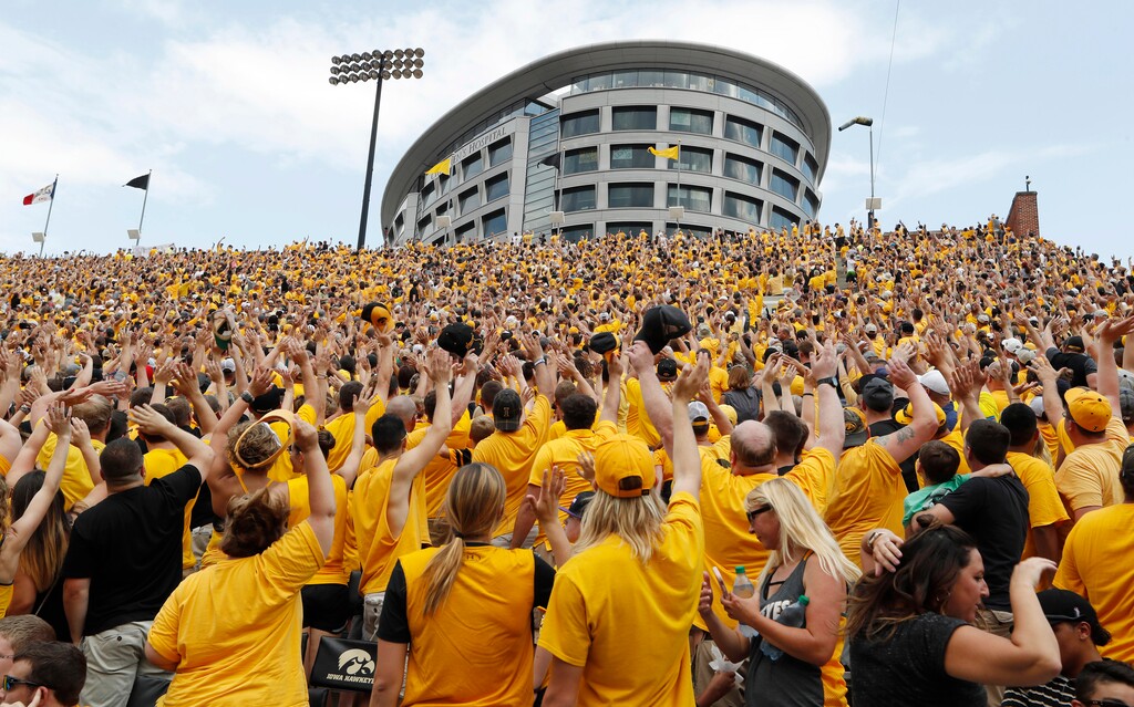 FILE - In this Saturday, Sept. 16, 2017 file photo, Iowa fans wave to children in the University of Iowa Stead Family Children's Hospital at the end of the first quarter of an NCAA college football game against North Texas in Iowa City, Iowa. The most heartwarming new tradition in college football can be found at Iowa. It’s called “The Wave.” At the end of the first quarter, everyone inside Kinnick Stadium is encouraged to turn and wave to the young patients watching the game in the nearby children’s hospital. (AP Photo/Charlie Neibergall, File)