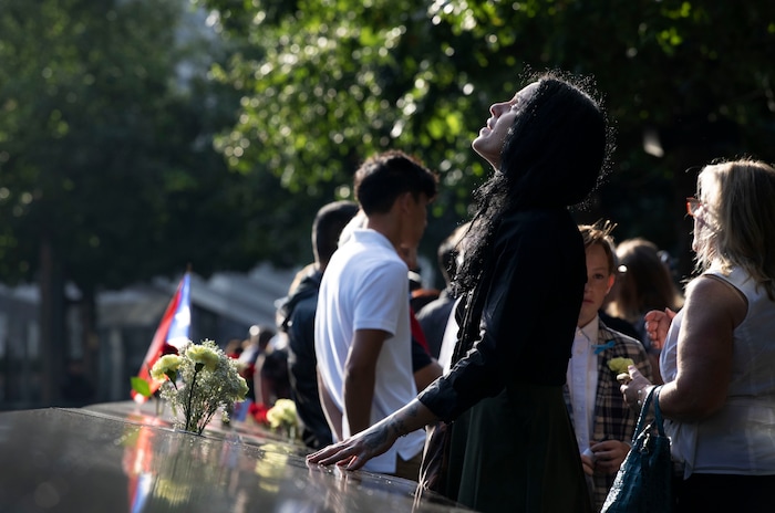 (Mark Lennihan | AP Photo) A woman stands next to the north pool prior to a ceremony marking the 18th anniversary of the attacks of Sept. 11, 2001 at the National September 11 Memorial, Wednesday, Sept. 11, 2019 in New York.