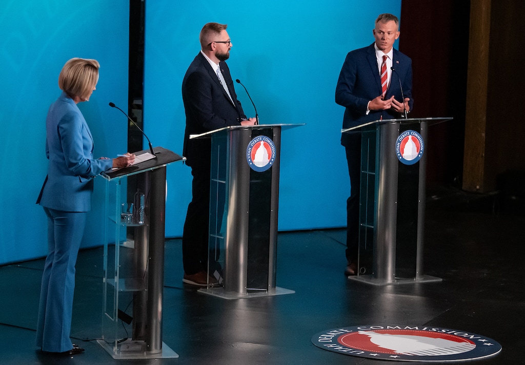 (Eli Lucero | Pool) Candidates for Utah's 2nd Congressional District, Democrat Peter Crosby, center, and Republican Blake Moore participate in a debate moderated by Heidi Hatch at Utah State University, Tuesday, Oct.13, 2026, in Logan, Utah.