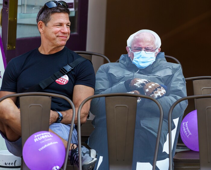 (Leah Hogsten | The Salt Lake Tribune) Alec Mutkus of Park City sits ourside of Park City Desserts & Coffee, watching the parade with a cardboard cutout of U.S. Senator Bernie Sanders on Main Street in Park City on Labor Day, Sept. 6, 2021 during its 125th anniversary celebration of MinersÕ Day.