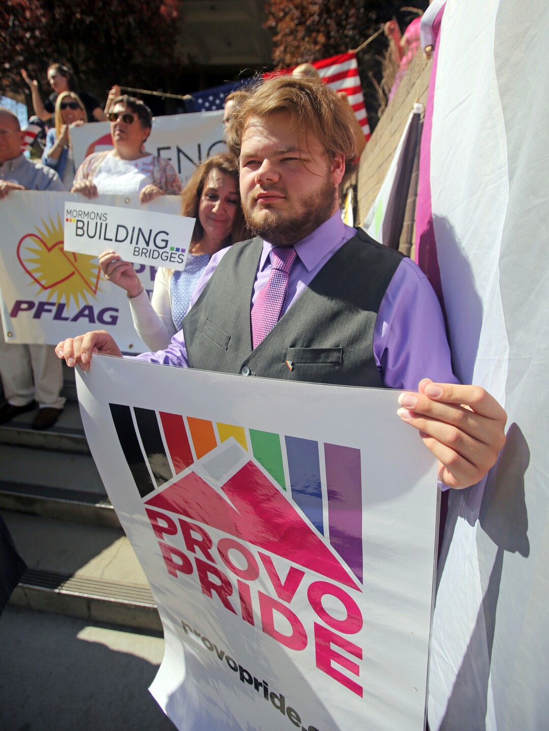 People hold signs during a news conference to discuss the America's Freedom Festival's decision Thursday, June 14, 2018, in Provo, Utah. LGBT groups that were denied requests to participate in a July 4 parade that is part of America's Freedom Festival in Provo spoke out Thursday about being rejected even after festival organizer and Provo city officials signed a nondiscrimination deal. (AP Photo/Rick Bowmer)