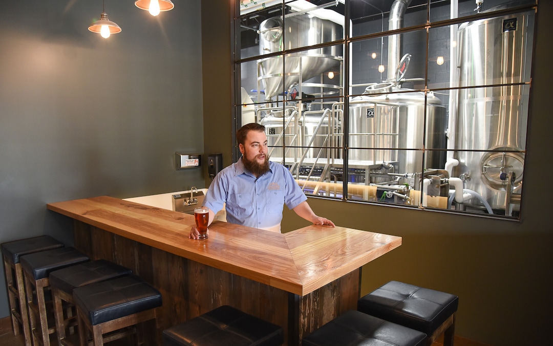 (Francisco Kjolseth  |  The Salt Lake Tribune)  Chris Detrick, head brewer for Level Crossing Brewing Co., shows off the tasting room with his new office in the background.