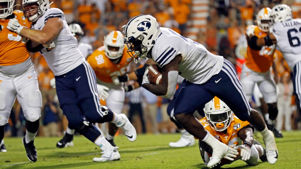 Brigham Young running back Ty'Son Williams (5) escapes the grasp of Tennessee linebacker Will Ignont (23) to score a touchdown on a 5-yard run to give his team a 29-26 win in overtime an NCAA college football game against Tennessee Saturday, Sept. 7, 2019, in Knoxville, Tenn. (AP Photo/Wade Payne)