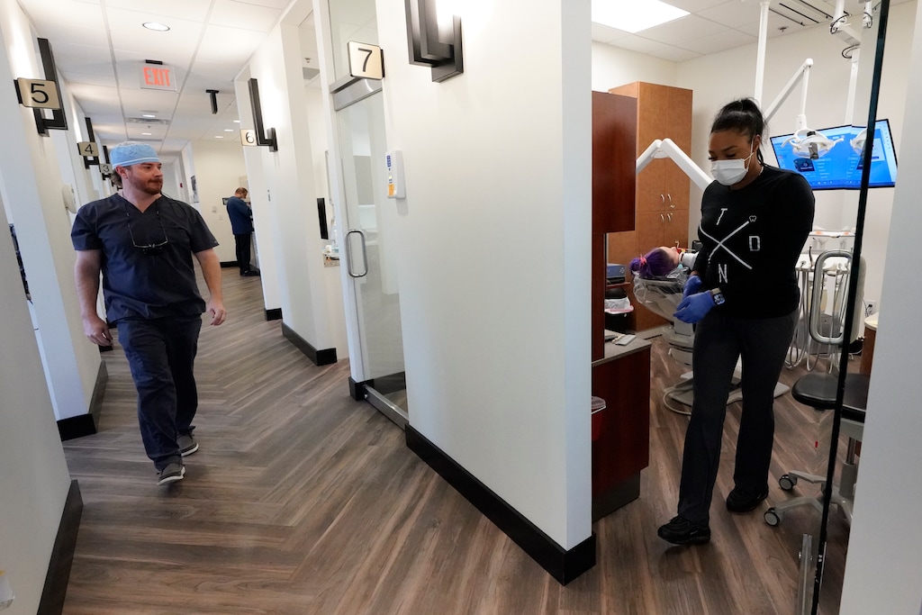(George Walker IV | The Associated Press) A dentist walks to a treatment room to visit with a patient Thursday, Sept. 7, 2023.