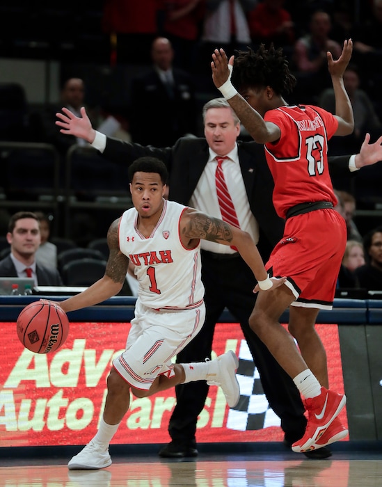Utah guard Justin Bibbins (1) drives against Western Kentucky guard Taveion Hollingsworth (13) during the first half of an NCAA college basketball game in the semifinals of the NIT, Tuesday, March 27, 2018, in New York. (AP Photo/Julie Jacobson)