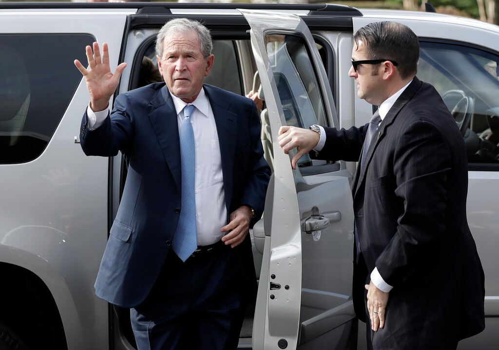 Former President George W. Bush, left, arrives to pay his respects to Billy Graham during a public viewing at the Billy Graham Library in Charlotte, N.C., Monday, Feb. 26, 2018. (AP Photo/Chuck Burton)