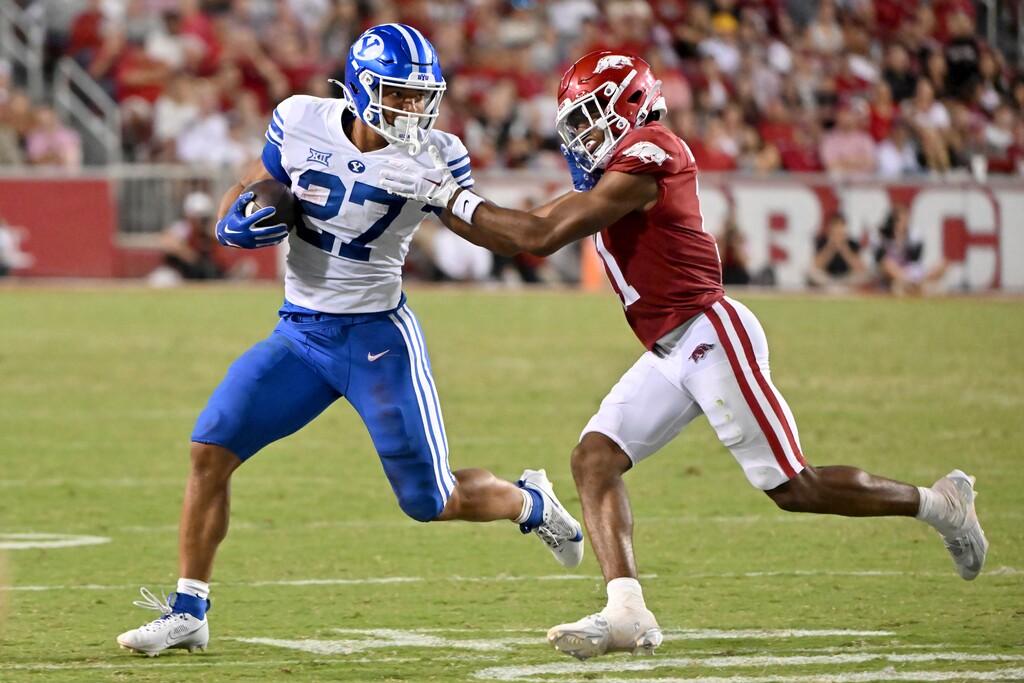 (Michael Woods | AP) BYU running back LJ Martin (27) tries to get past Arkansas defensive back Jaylon Braxton (11) during the second half of an NCAA college football game Saturday, Sept. 16, 2023, in Fayetteville, Ark.