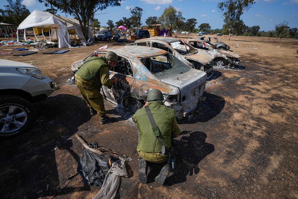 (Ariel Schalit |AP) Israeli soldiers inspect the site of a music festival near the border with the Gaza Strip in southern Israel, Friday. Oct. 13, 2023.
