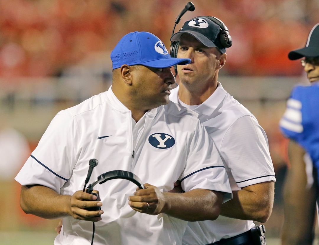 In this Sept. 10, 2016, photo, BYU offensive coordinator Ty Detmer, right, holds head coach Kalani Sitake as he reacts to a call from a referee in the second half during an NCAA college football game against Utah, in Salt Lake City. The honeymoon between BYU fans and former Heisman winner Detmer may be coming to an end. Boos rained down from the stands last week as the offense continued to struggle. Sitake said Hill will remain the starter this week after the staff considered benching the senior at halftime of the 17-14 UCLA loss. (AP Photo/Rick Bowmer)