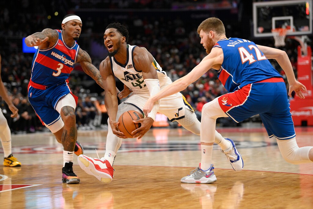Utah Jazz guard Donovan Mitchell (45) drives to the basket against Washington Wizards guard Bradley Beal (3) and forward Davis Bertans (42) during the first half of an NBA basketball game Saturday, Dec. 11, 2021, in Washington. (AP Photo/Nick Wass)