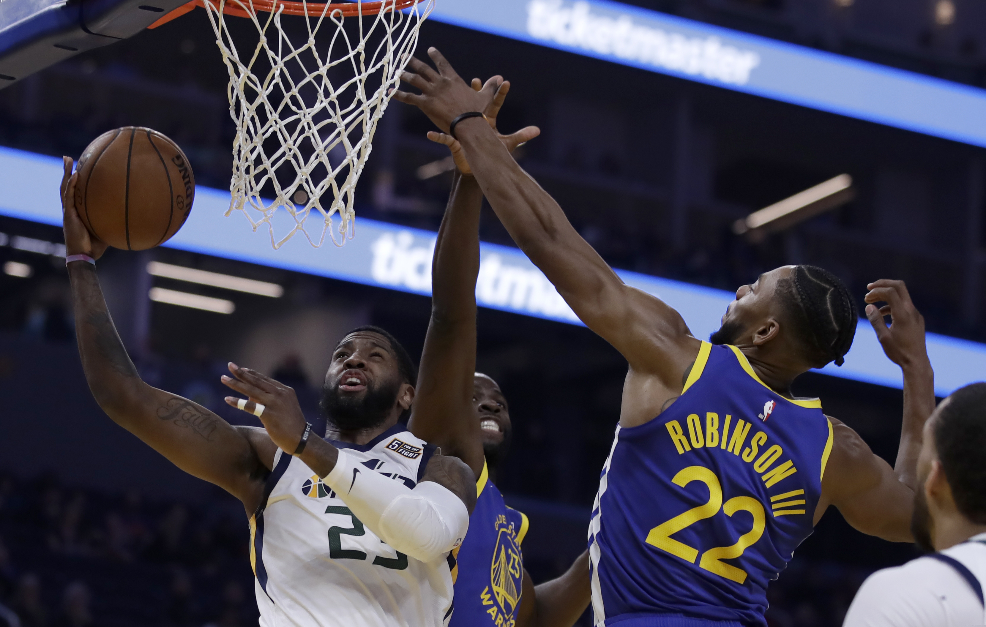 Utah Jazz forward Royce O'Neale, left, shoots against Golden State Warriors' Draymond Green, center, and Glenn Robinson III (22) in the first half of an NBA basketball game Wednesday, Jan. 22, 2020, in San Francisco. (AP Photo/Ben Margot)