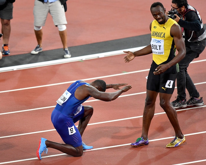 Justin Gatlin, ganador de la medalla de oro, se arrodilla frente a Usain Bolt, ganador del bronce, tras la final de los 100 metros en el Mundial de atletismo, en Londres, el sábado 5 de agosto de 2017. (AP Foto/Martin Meissner)