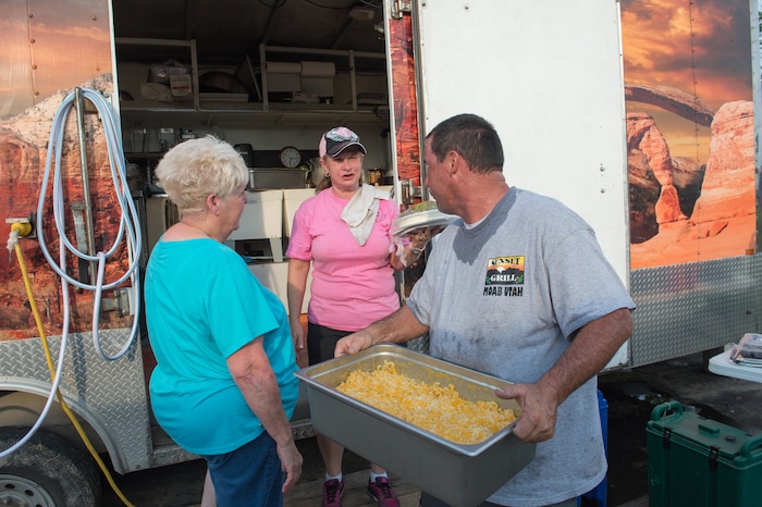 Rachel Molenda  |  The Salt Lake Tribune)  John Clayton, who owns Sunset Grill in Moab, Utah, speaks with Johnie Powell, left, and Mary Jones, center, in Kountze, Texas, on Tuesday, Sept. 7, 2017. Clayton, along with his wife Laurie and daughter Emma, drove their mobile kitchen to the town to provide meals to those impacted by Hurricane Harvey.