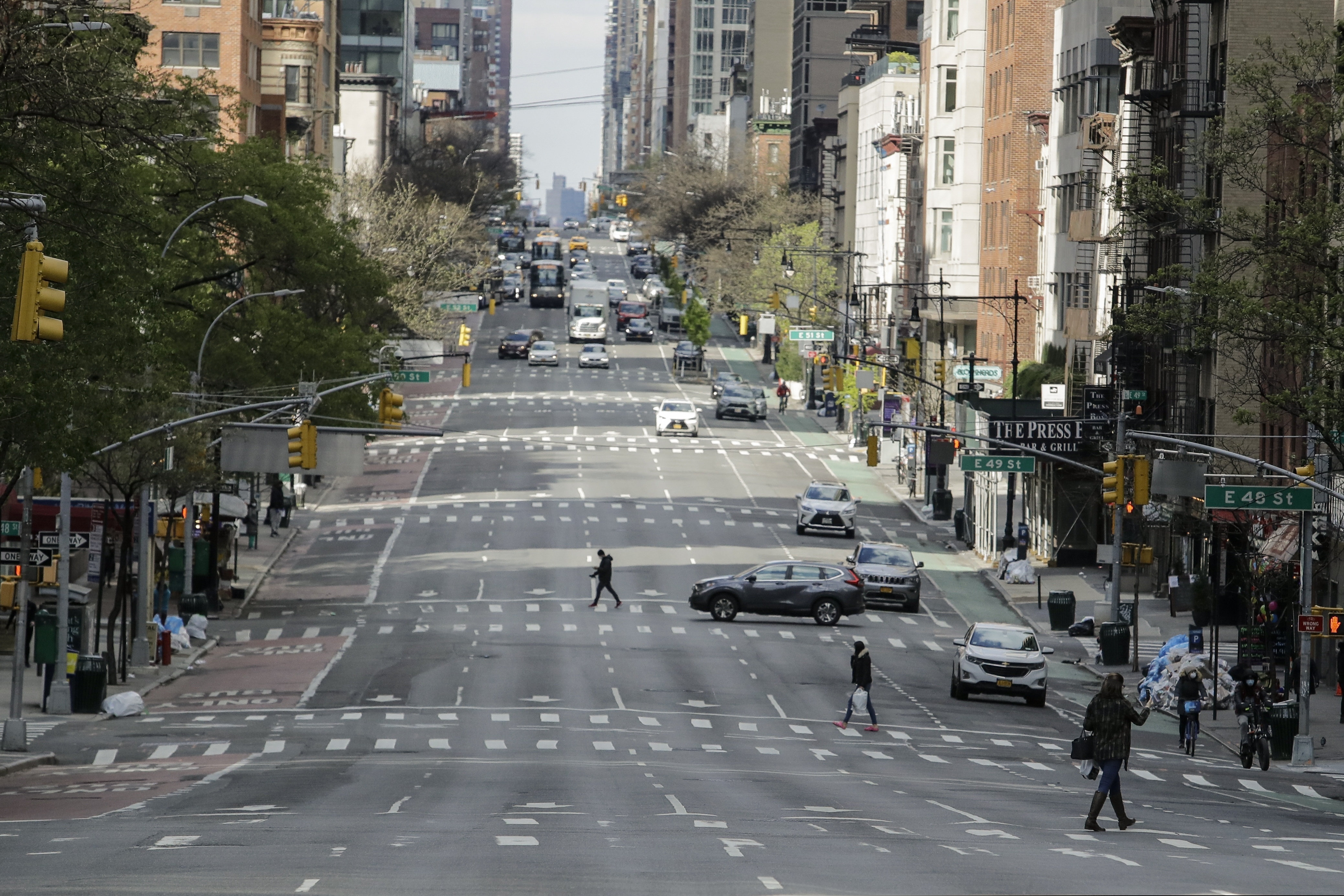 Pedestrians cross second avenue Thursday, April 16, 2020, in New York. New York planned for a long fight against the coronavirus outbreak amid hopeful hospitalization trends. Gov. Andrew Cuomo extended stay-at-home restrictions Thursday through mid-May and New York City is getting ready to use 11,000 empty hotel rooms for coronavirus quarantines. (AP Photo/Frank Franklin II)