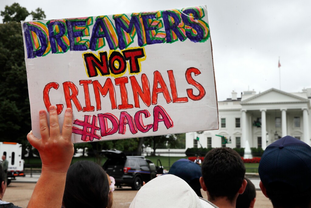 FILE- In this Aug. 15, 2017, file photo, a woman holds up a sign in support of the Obama administration program known as Deferred Action for Childhood Arrivals, or DACA, during an immigration reform rally at the White House in Washington. (AP Photo/Jacquelyn Martin, File)