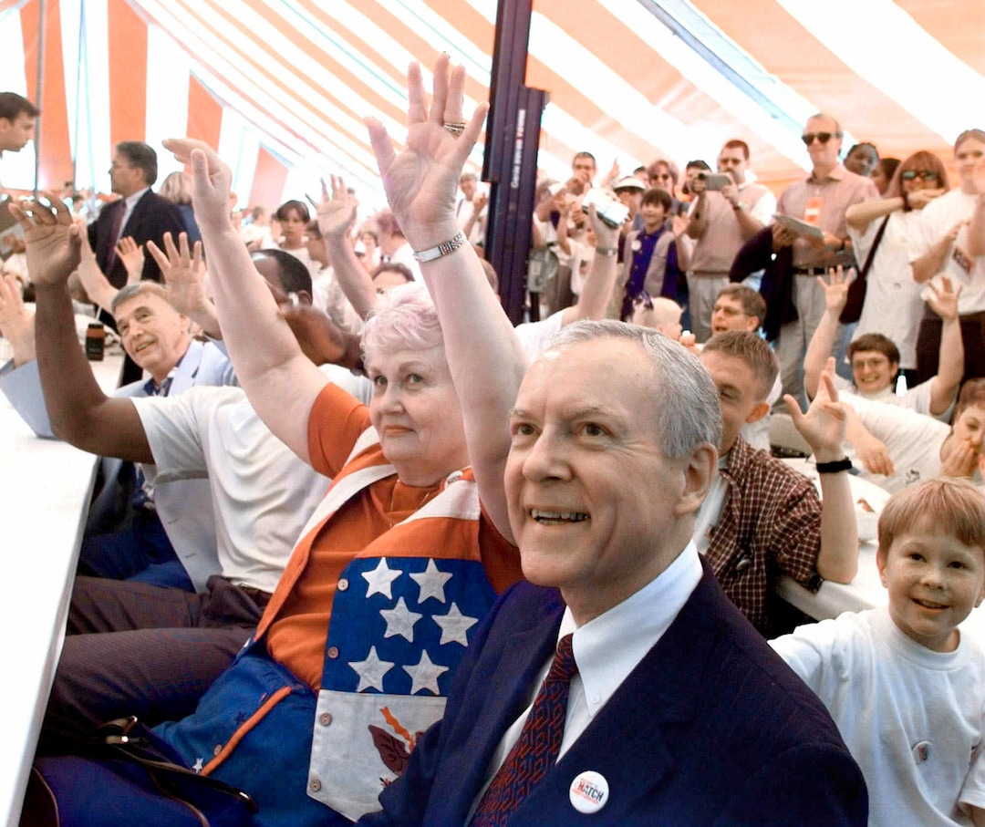 (Cliff Schiappa | AP) Republican presidential hopeful Orrin Hatch, foreground, smiles as his wife, Elaine, shown seated next to Hatch, and others follow the directions of an entertainer performing at a Hatch for President rally in Ames, Iowa, prior to the Iowa Straw Poll Saturday, Aug. 14, 1999.