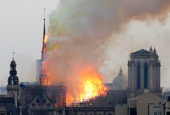 Flames rise from Notre Dame cathedral as it burns in Paris, Monday, April 15, 2019. Massive plumes of yellow brown smoke is filling the air above Notre Dame Cathedral and ash is falling on tourists and others around the island that marks the center of Paris. (AP Photo/Thibault Camus)
