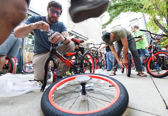 (Francisco Kjolseth  |  The Salt Lake Tribune)  Mike Rizk joins other volunteers and workers at Squatter's Pub Brewery to assemble 80 bicycles on Tuesday, May 29, 2018, at the brewery which will be given away to 1st and 2nd graders at Washington Elementary on Wednesday. Part of the program is backed by the Can'd Aid Foundation.