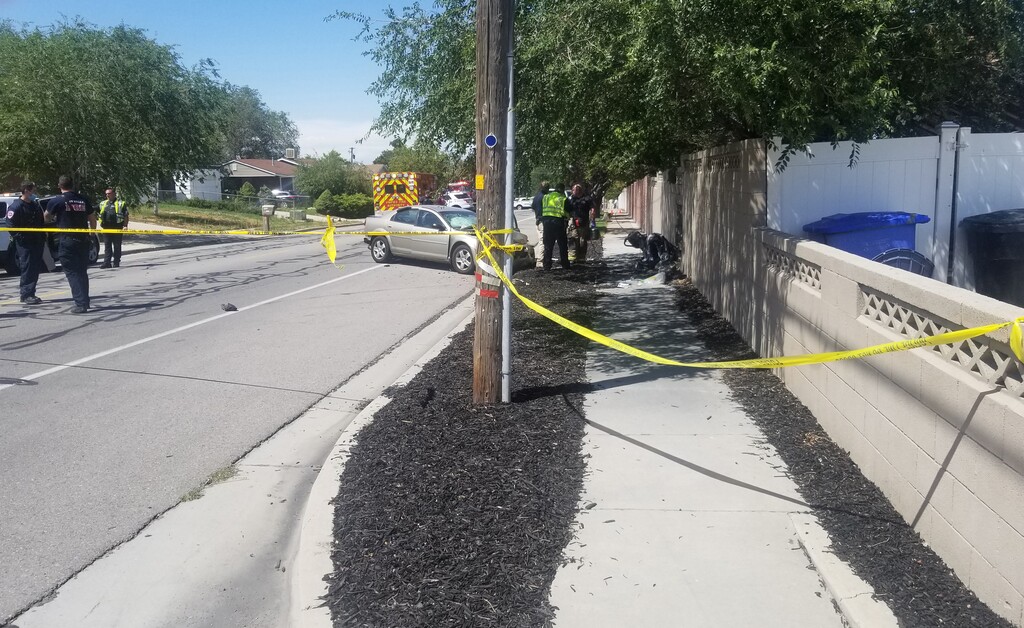 (Dan Harrie | The Salt Lake Tribune) Emergency crews respond to a car crash near 5095 South 3200 W. in Taylorsville, Tuesday, July 28, 2020. At right is a baby stroller that was reportedly carrying two young girls and was being pushed down the sidewalk by the mother when a car was rear-ended and pushed into the pedestrians.