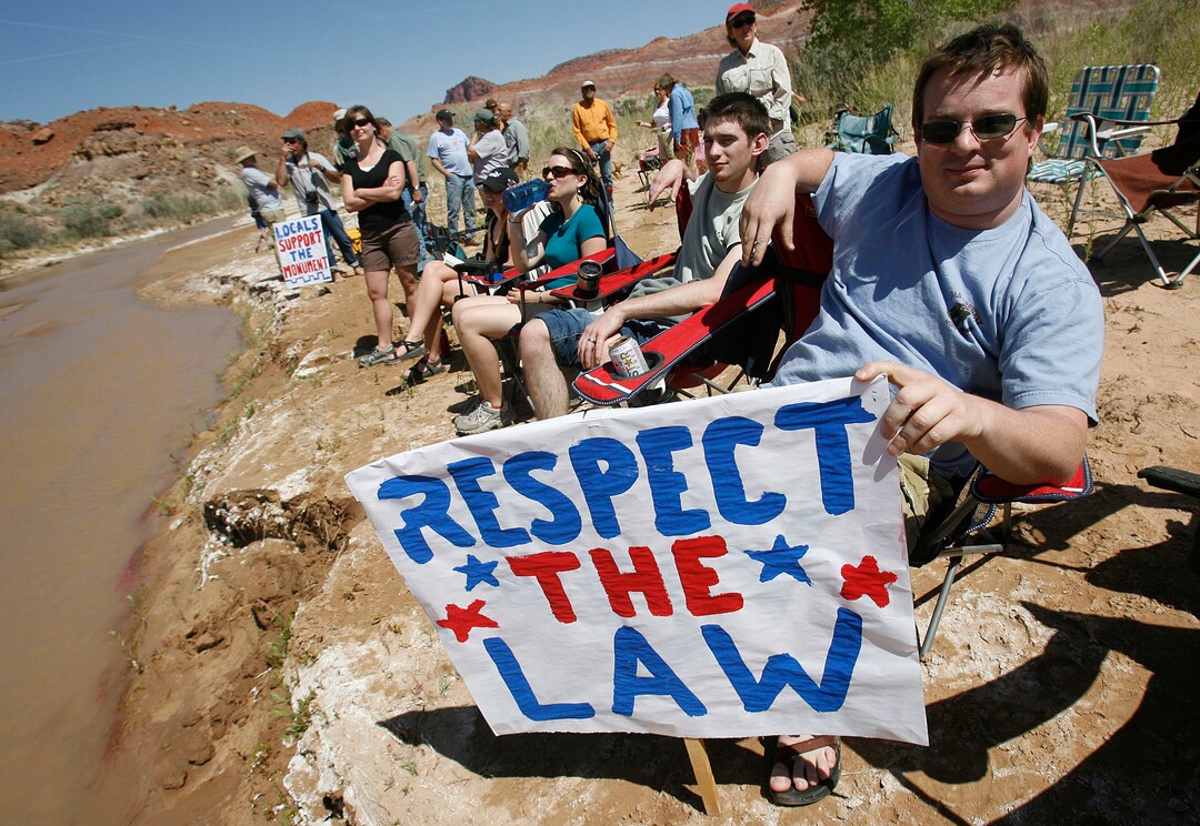 (Scott Sommerdorf  |  Tribune File Photo)  At right, Justin Miller, of Salt Lake City, and other anti-ATV protesters at the "Picnic with a Purpose" make their point to ATV'ers as they pass this spot on the Paria riverbed. ATV and off-road vehicle riders numbering about 100 protested BLM road closures in Grand Staircase-Escalante National Monument on Saturday.