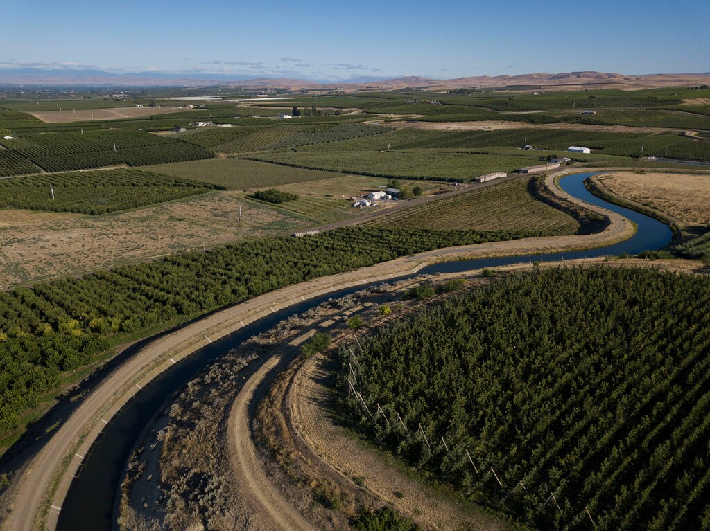 (Ruth Fremson | The New York Times) An irrigation canal, lined with concrete to conserve water, in the Roza Irrigation District, in Washington State, on July 14, 2022. Success in the Yakima River Basin in Washington holds lessons for the seven states at war over water in the American West.