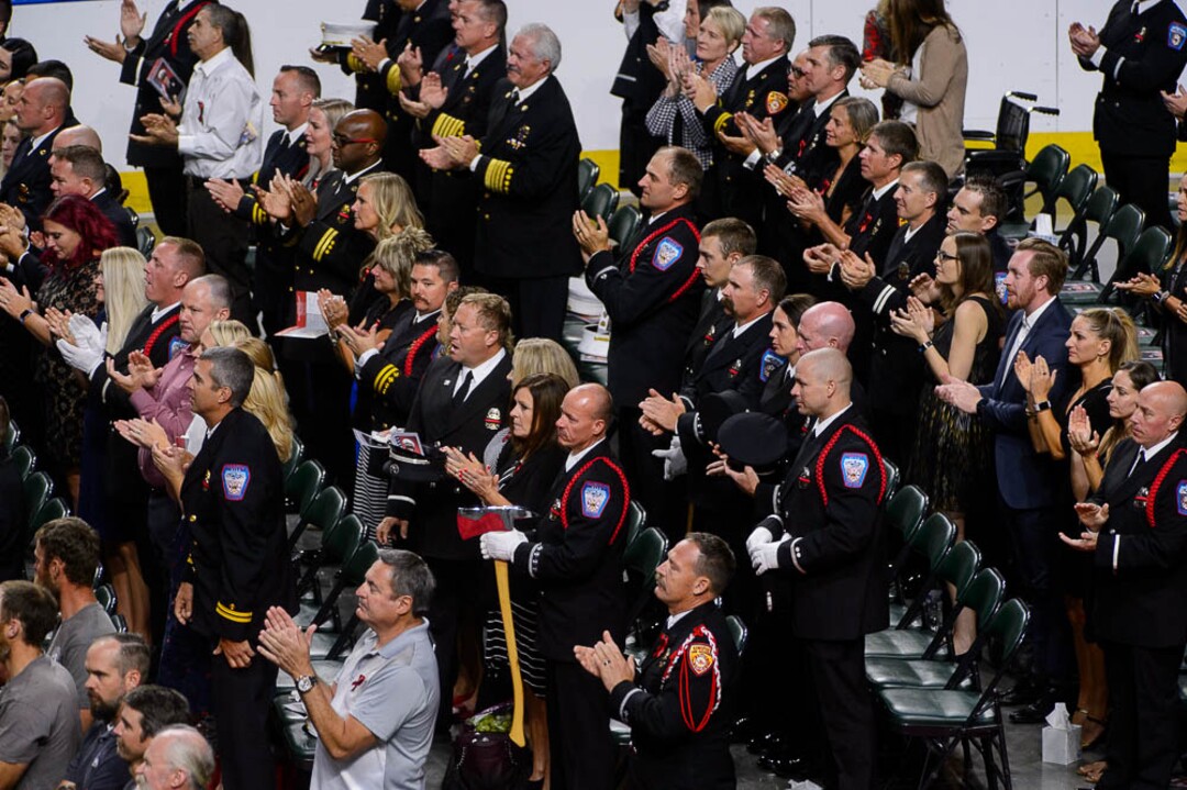 (Trent Nelson | The Salt Lake Tribune)  Audience members applaud at the funeral services for Battalion Chief Matthew Burchett at the Maverik Center in West Valley City, Monday Aug. 20, 2018.