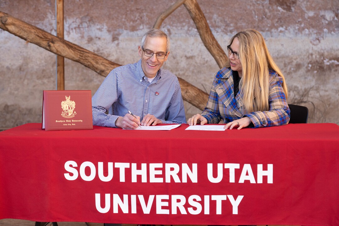 (Photo courtesy of Southern Utah University) SUU President Scott Wyatt and Best Friends Animal Society Executive Director Julie Castle sign a partnership agreement on Tuesday, Dec. 12, 2019.