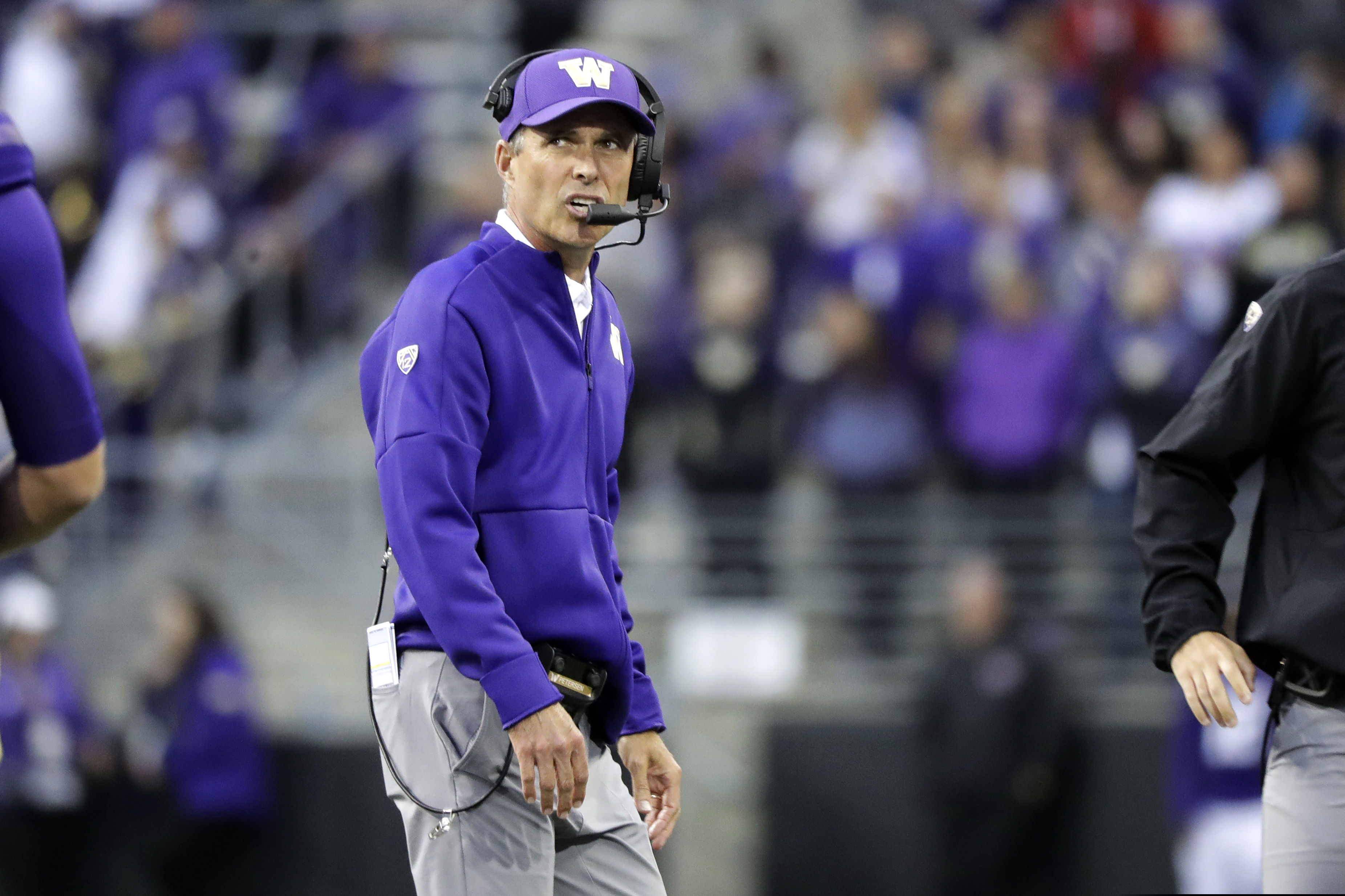 Washington head coach Chris Petersen talks on his headset during the second half of an NCAA college football game against Hawaii, Saturday, Sept. 14, 2019, in Seattle. Washington won 52-20. (AP Photo/Ted S. Warren)