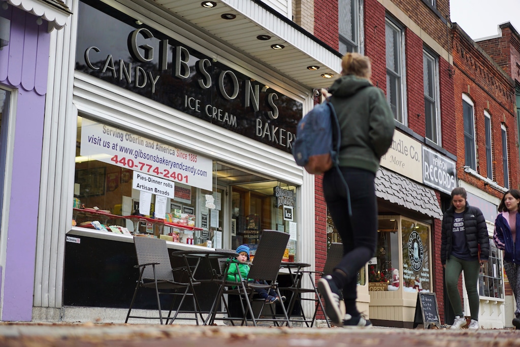 (Dake Kang | AP file photo) Pedestrians pass the storefront of Gibson's Food Mart & Bakery in Oberlin, Ohio, in 2017. A jury has awarded $11 million to a father and son who claimed Ohio's Oberlin College and an administrator hurt their business and libeled them during a dispute that triggered protests and allegations of racism following a shoplifting incident.