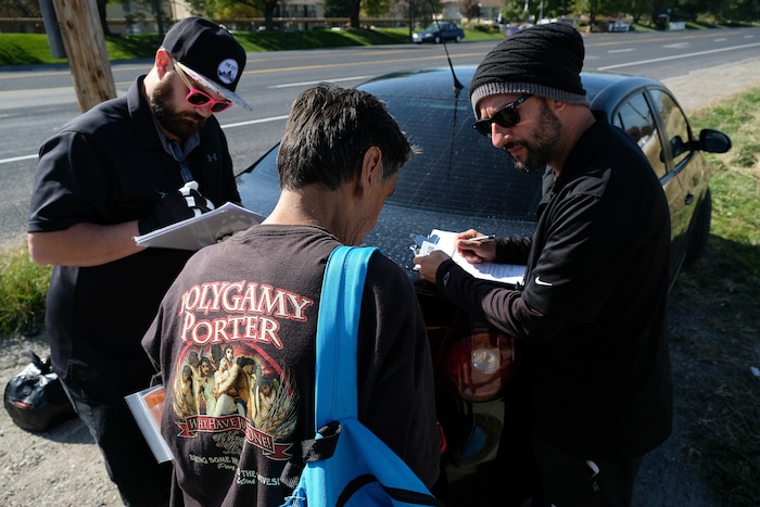 (Francisco Kjolseth  |  The Salt Lake Tribune)  Alex Larson, left, and Patrick Rezac, right, Executive Director of One Voice Recovery, check in with Ivan Vasquez, 58, who is homeless and a heroin user in West Salt Lake recently. In an effort to curb the incidents of hepatitis C, HIV and STD's, Rezac's grass roots team hands out disease prevention kits and provides a needle exchange program.