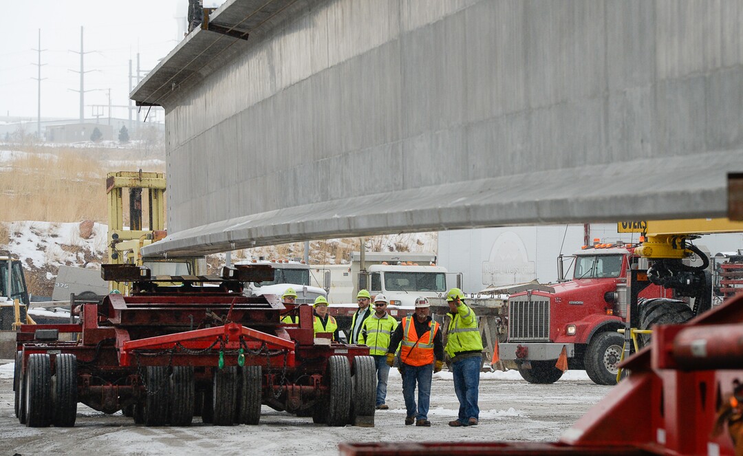 (Francisco Kjolseth  |  The Salt Lake Tribune)  UDOT gets ready to place some of the world's largest-ever bridge beams, and the largest in Utah state history with a span of 203 ft long and just over 8 ft tall, as crews load one on a truck following manufacturing at Forterra Structural Precast in Kearns on Tuesday, Dec. 11, 2018. A total of six beams will be installed in the technology corridor in Lehi later this week.