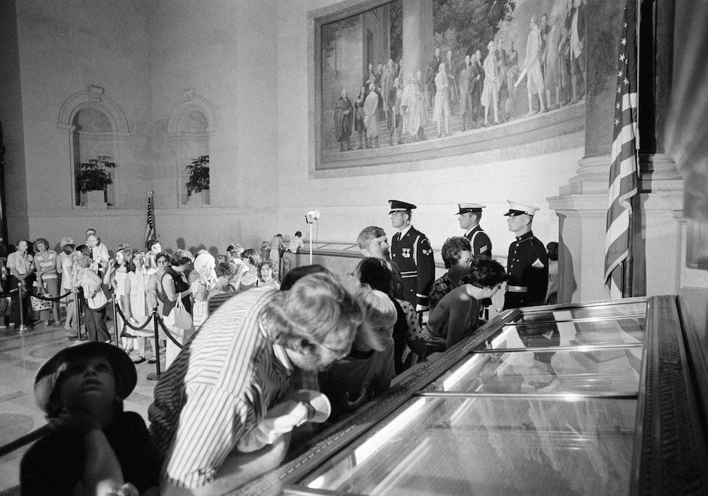 Visitors view the Declaration of Independence in the National Archives the nation's 200th birthday in Washington Sunday, July 4, 1976. The Declaration, on which the nation was founded, was placed on view for 96 straight hours during the Bicentennial celebration. (AP Photo)