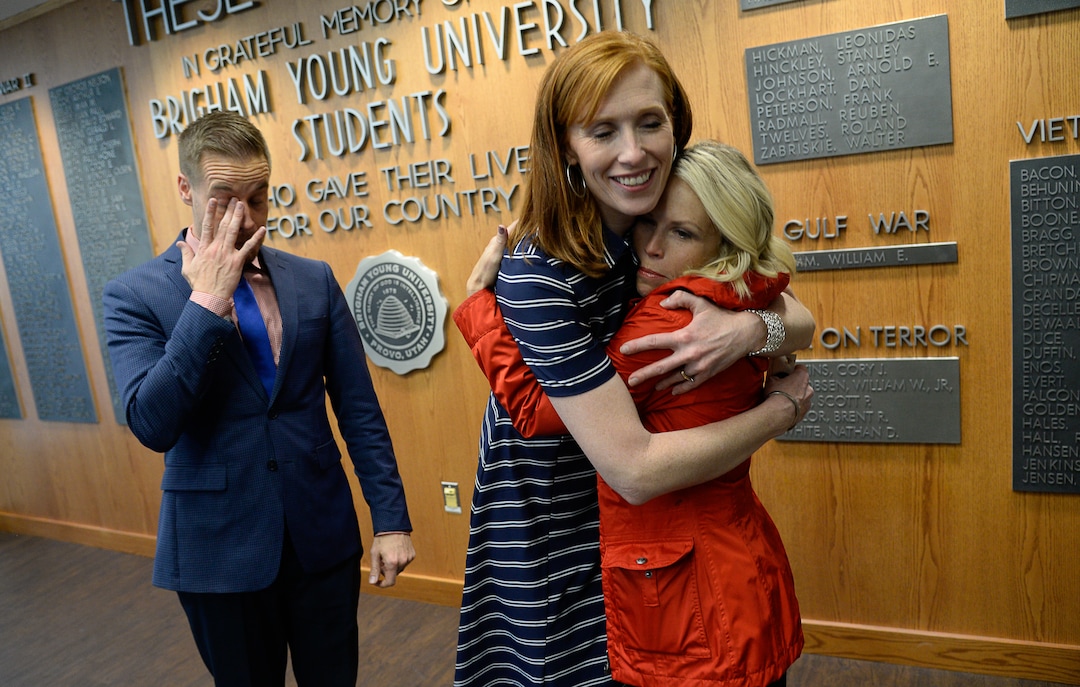 (Francisco Kjolseth  |  The Salt Lake Tribune)  Jennie Taylor, center, is embraced by friends Becky Bybee and her husband Brenn following a ceremony at Brigham Young University that honored the life and legacy of Jennie's husband, Major Brent Taylor, former mayor of North Ogden and a BYU Army ROTC alumnus during a ceremony at the Ernest L. Wilkinson Student Center in Provo on Thursday, May 23, 2019. The BYU Army ROTC also unveiled the updated Memorial Wall, a list of BYU students and alumni who have died in service which will now include Major Taylor's name.