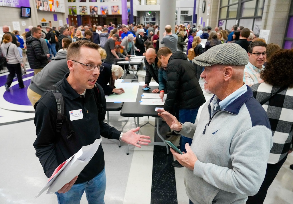 (Bethany Baker  |  The Salt Lake Tribune) Caucus volunteer Stewart Grow speaks with a Republican caucusgoer during the presidential primary caucuses at Riverton High School in Riverton on Tuesday, March 5, 2024.