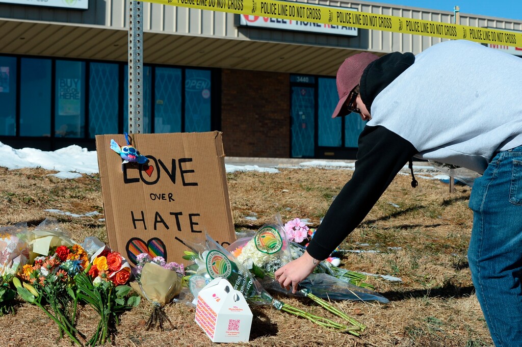 (Geneva Heffernan | AP Photo) Elijah Newcomb of Colorado Springs lays flowers near a gay nightclub in Colorado Springs, Colo., Sunday, Nov. 20, 2022 where a shooting occurred late Saturday night.