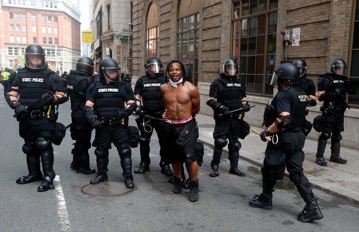 Police escort away a counterprotester near a "Free Speech" rally staged by conservative activists, Saturday, Aug. 19, 2017, in Boston. An estimated 15,000 counterprotesters marched through the city to historic Boston Common, where many gathered near a bandstand abandoned early by conservatives who had planned to deliver a series of speeches. Police vans later escorted the conservatives out of the area, and angry counterprotesters scuffled with armed officers trying to maintain order.
 (AP Photo/Michael Dwyer)