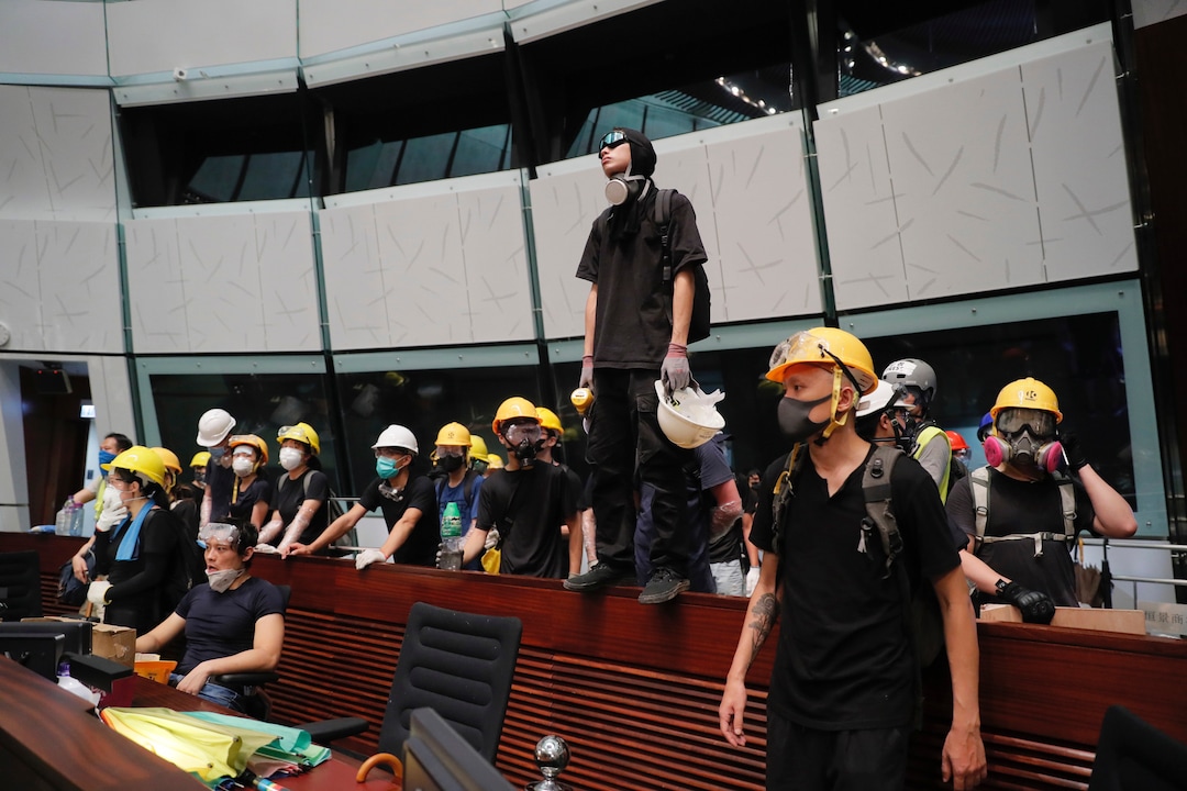 (Kin Cheung | AP Photo) Protesters gather inside the meeting hall of the Legislative Council in Hong Kong, Monday, July 1, 2019. Protesters in Hong Kong took over the legislature's main building Friday night, tearing down portraits of legislative leaders and spray painting pro-democracy slogans on the walls of the main chamber.
