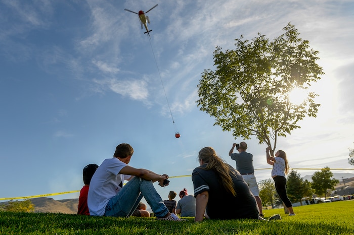 Leah Hogsten  |  The Salt Lake Tribune   Homeowners who were not allowed to return to their homes and onlookers waited near Herriman Cove pond to watch as a firefighting helicopter refilled. A 50-acre wildfire in Rose Canyon was threatened about a half-dozen homes Wednesday, Sept. 12, 2018. A spokesman for Unified Fire said the blaze has already burned a few structures, including outhouses and sheds. Firefighters have evacuated around 20 to 30 homes in two neighborhoods near 15555 S. Rose Canyon Road in Herriman. 